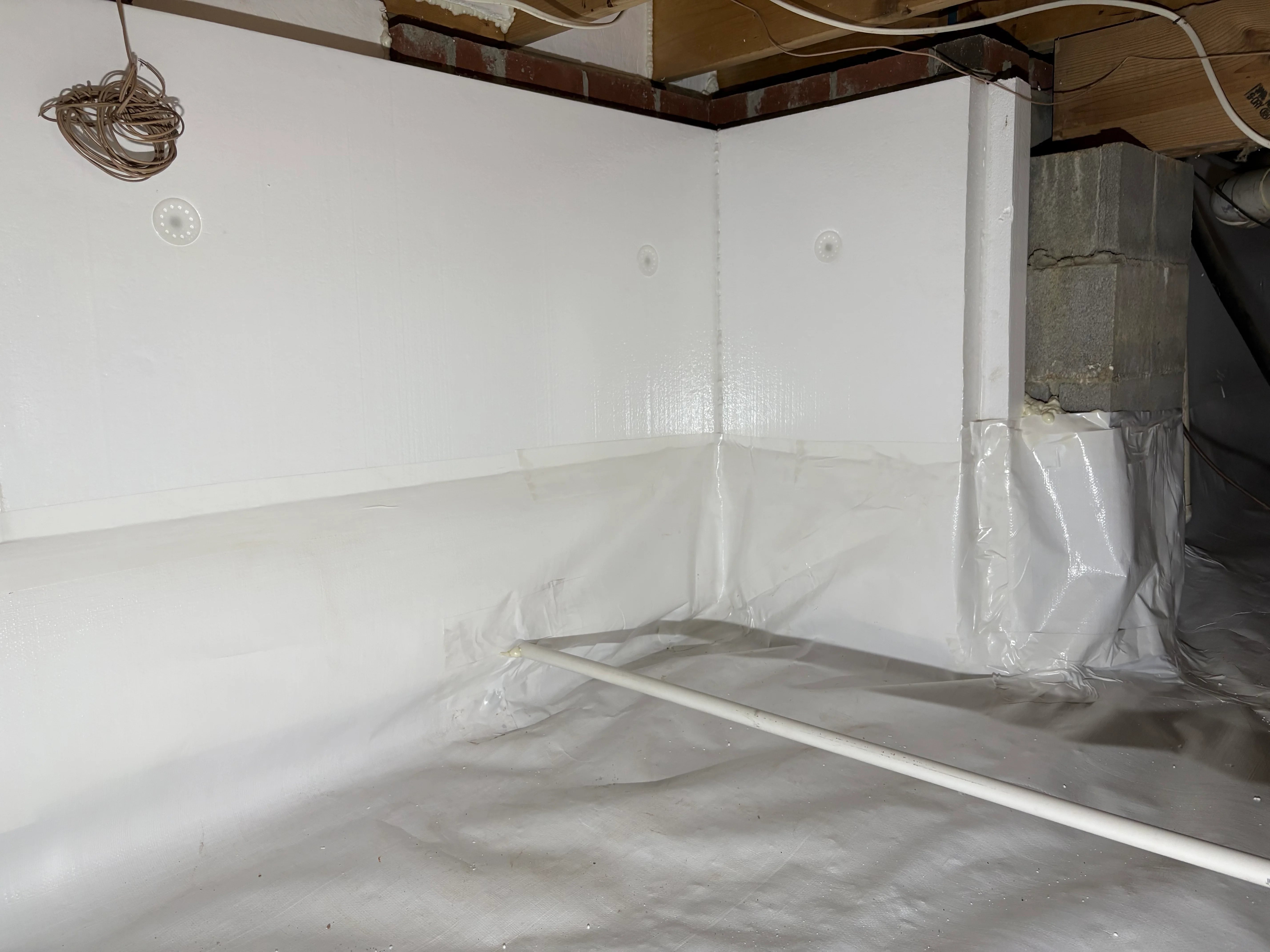 White vapor barrier encapsulation in crawl space with sealed walls and floor protection