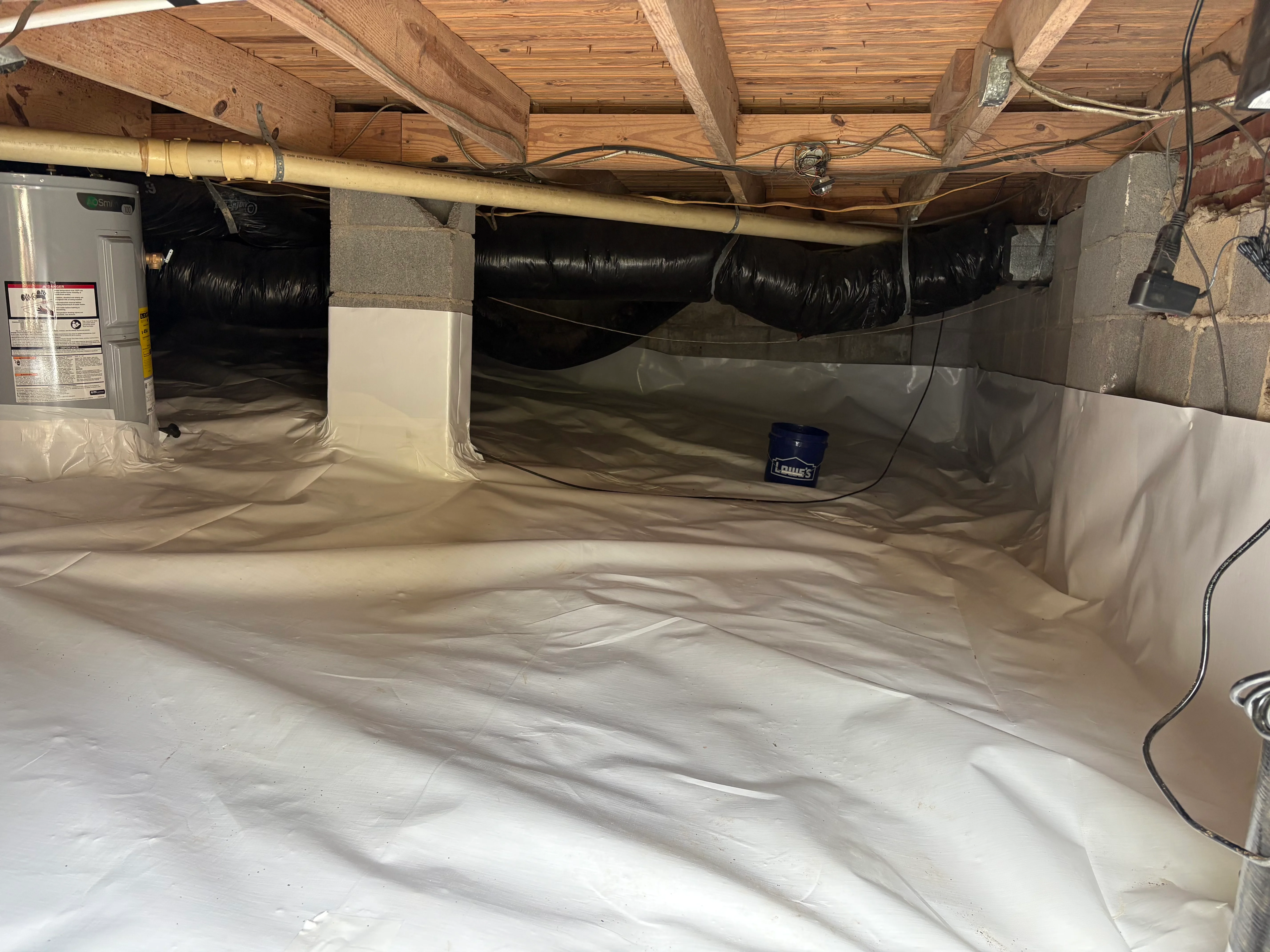 Crawl space with white vapor barrier encapsulation, sealed ducts, and wooden beams