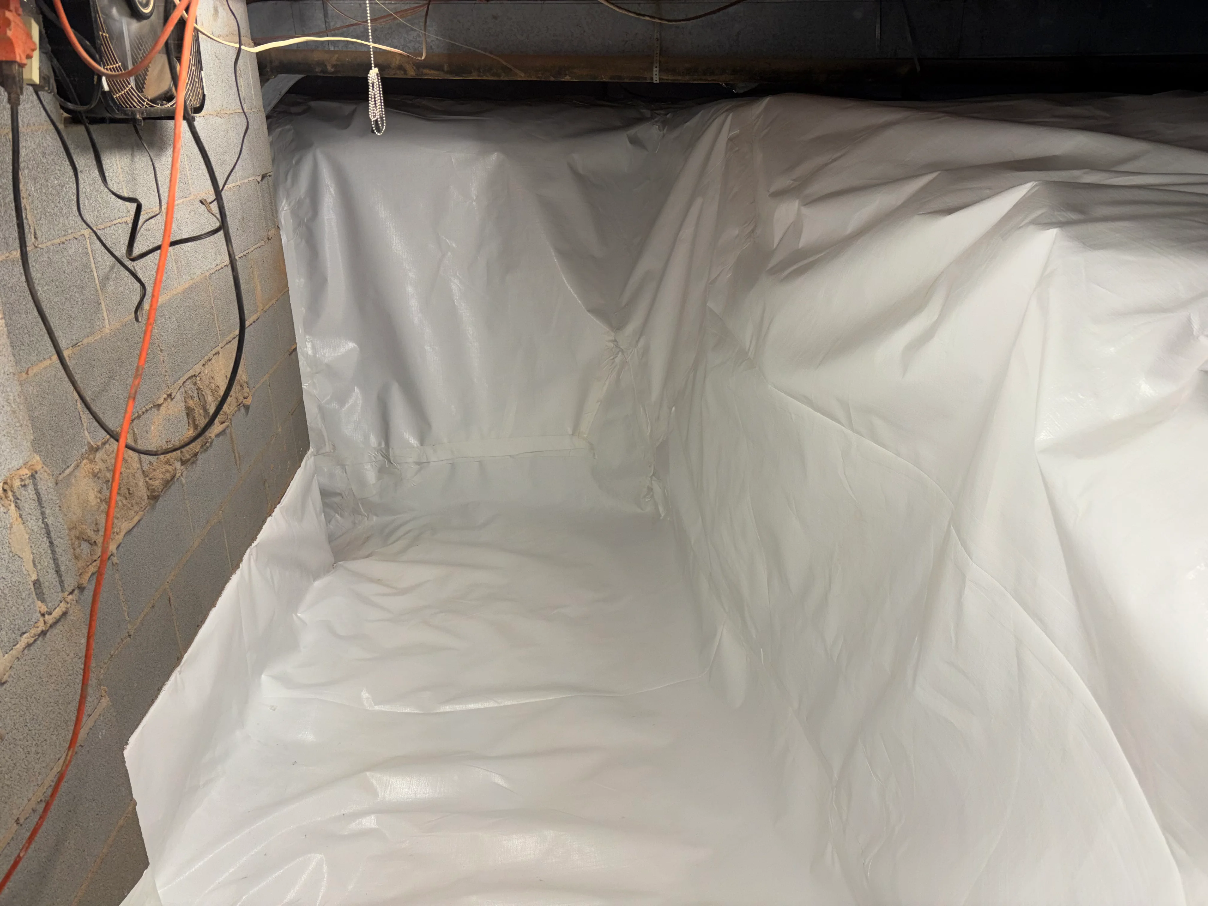White vapor barrier encapsulation installed in crawl space with sealed walls and floor
