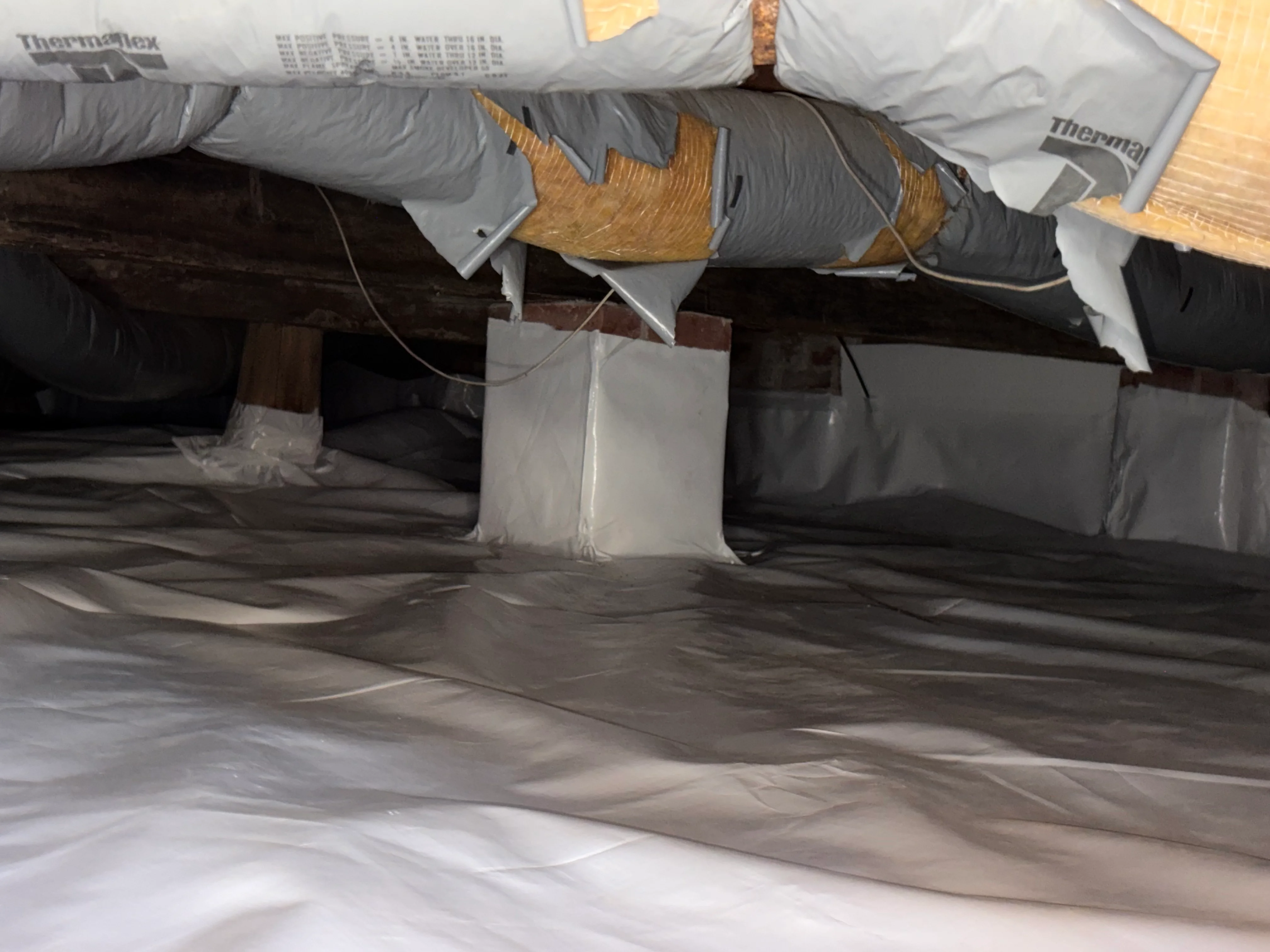 Crawl space encapsulation with Thermaflex insulation on ducts and vapor barrier system