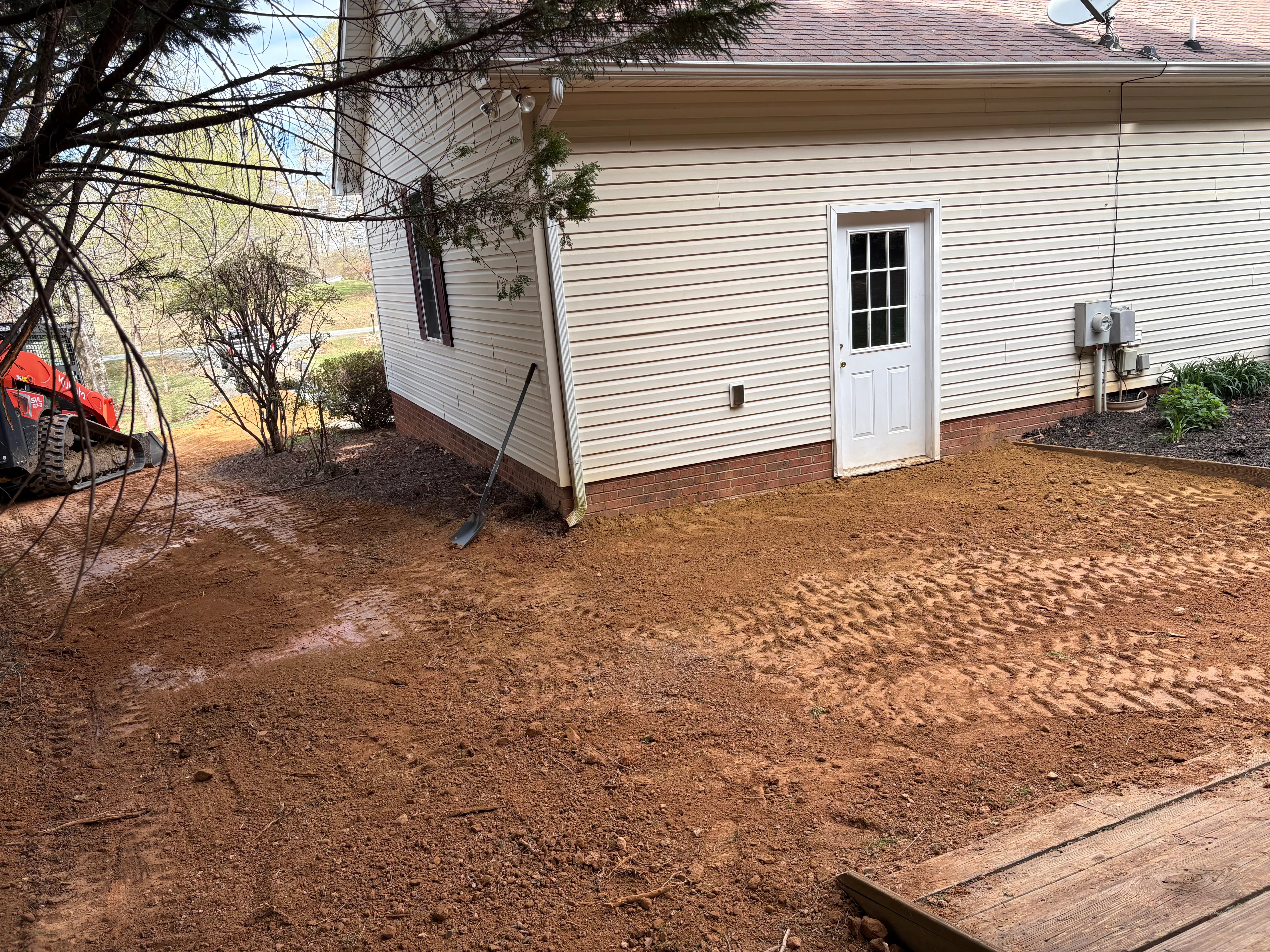 Excavated and graded crawl space area with compacted soil around home foundation