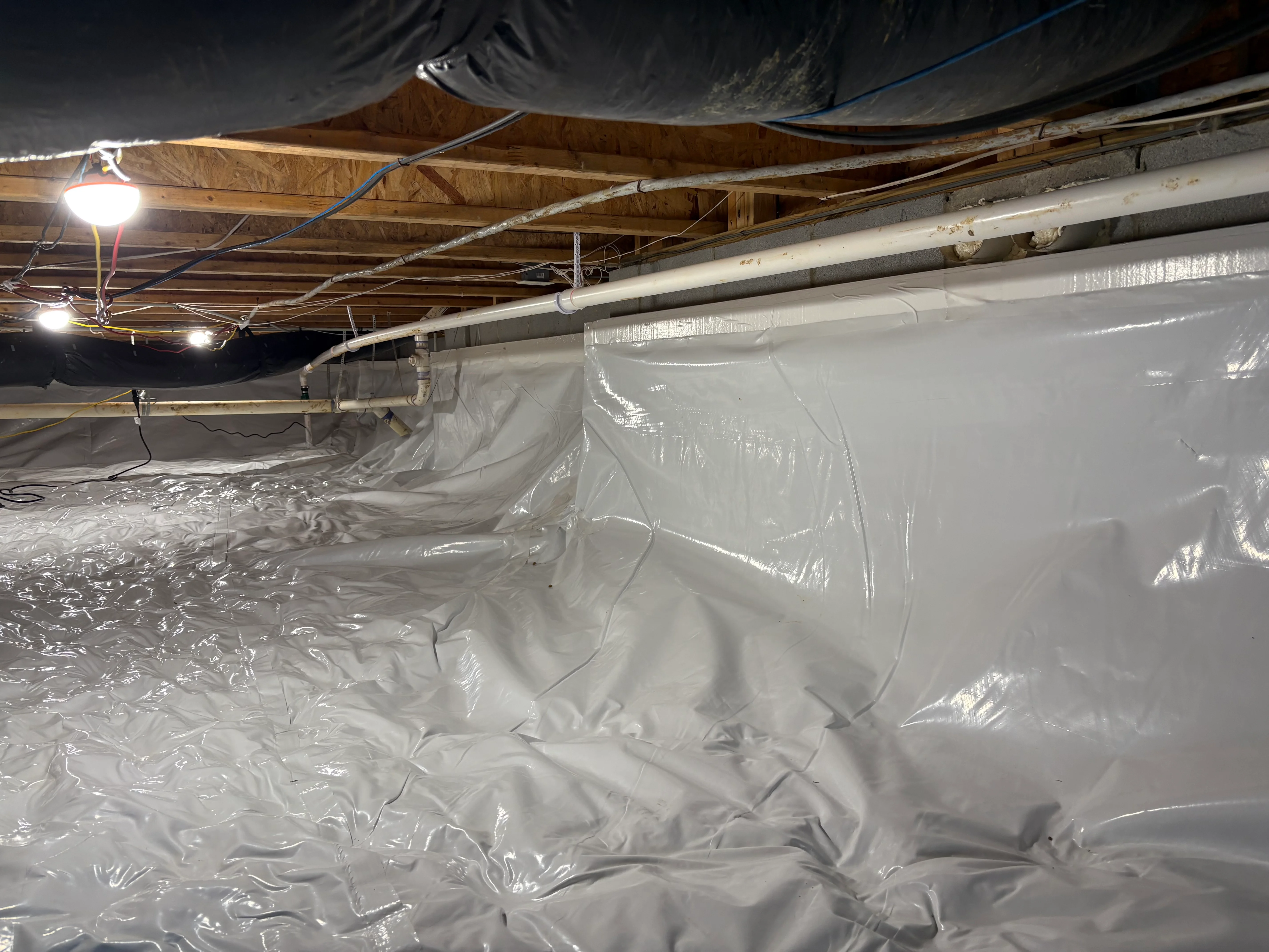 Crawl space with white polyethylene vapor barrier encapsulation and LED lighting